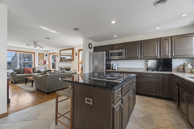 15 Buckingham Ave, Old Saybrook, CT 06475 - kitchen featuring stainless steel appliances, dark brown cabinets, light tile patterned floors, a kitchen breakfast bar, and a ceiling fan