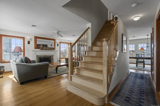 15 Buckingham Ave, Old Saybrook, CT 06475 - stairs featuring wood finished floors, ceiling fan, and a fireplace
