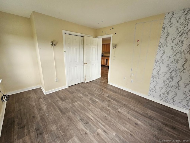 205 Flanders Rd, East Lyme, CT 06357 - unfurnished bedroom with wood finished floors, baseboards, and a closet