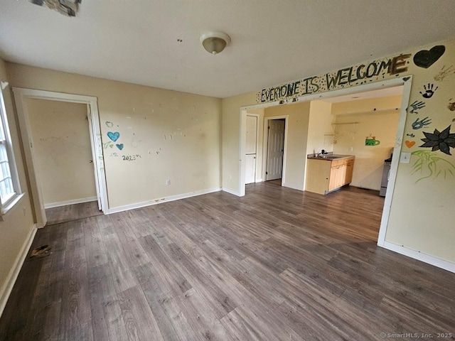 205 Flanders Rd, East Lyme, CT 06357 - unfurnished living room featuring dark wood-type flooring, baseboards, and a sink