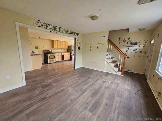 205 Flanders Rd, East Lyme, CT 06357 - unfurnished living room with dark wood-style flooring, stairway, and baseboards