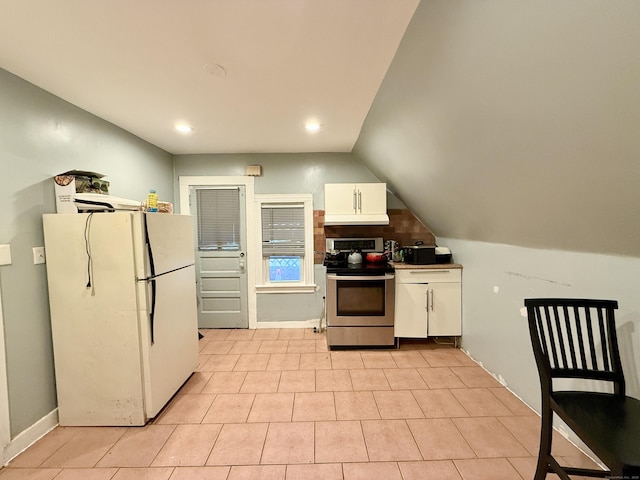 kitchen with light tile patterned floors, freestanding refrigerator, under cabinet range hood, white cabinetry, and stainless steel range with electric cooktop