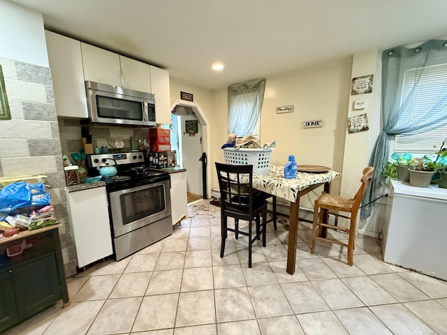 kitchen featuring stainless steel appliances, tasteful backsplash, white cabinets, and a healthy amount of sunlight