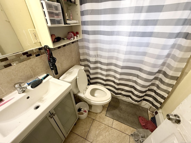full bathroom featuring vanity, curtained shower, tile patterned flooring, toilet, and tile walls