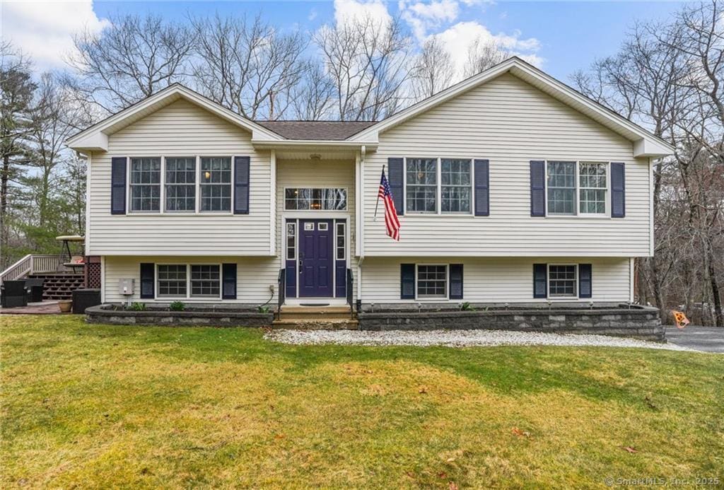bi-level home with a front lawn and roof with shingles