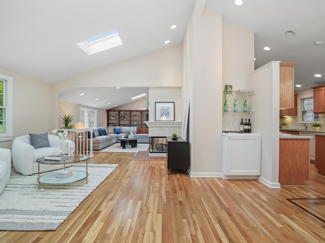 8 Argentine Way, Norwalk, CT 06850 - living area featuring light wood-style floors, a skylight, recessed lighting, a multi sided fireplace, and high vaulted ceiling
