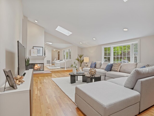 8 Argentine Way, Norwalk, CT 06850 - living room featuring plenty of natural light, lofted ceiling, a multi sided fireplace, light wood finished floors, and a skylight