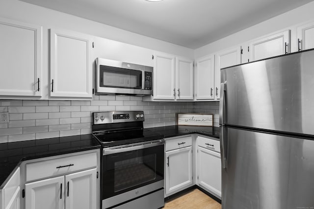 136 Pembroke Rd Unit 6-49, Danbury, CT 06811 - kitchen with white cabinetry, backsplash, dark countertops, and stainless steel appliances