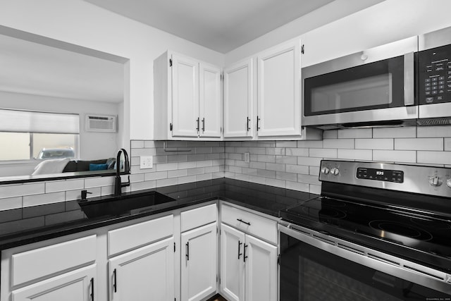 136 Pembroke Rd Unit 6-49, Danbury, CT 06811 - kitchen featuring dark countertops, white cabinetry, tasteful backsplash, a sink, and appliances with stainless steel finishes