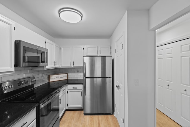 136 Pembroke Rd Unit 6-49, Danbury, CT 06811 - kitchen featuring appliances with stainless steel finishes, tasteful backsplash, dark countertops, light wood-style floors, and white cabinetry
