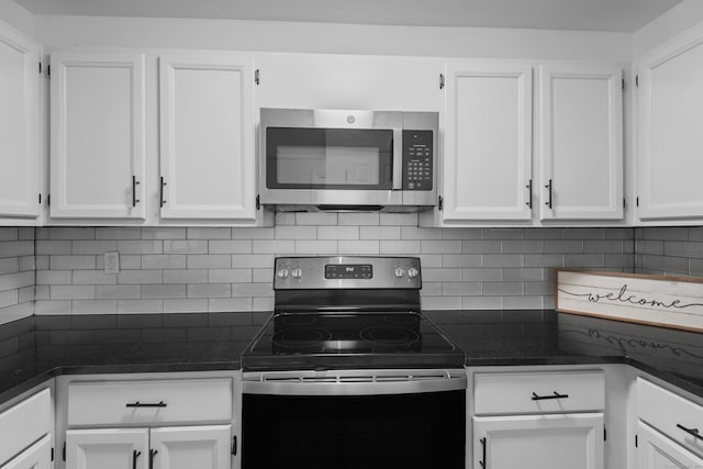 136 Pembroke Rd Unit 6-49, Danbury, CT 06811 - kitchen with dark countertops, white cabinets, backsplash, and stainless steel appliances