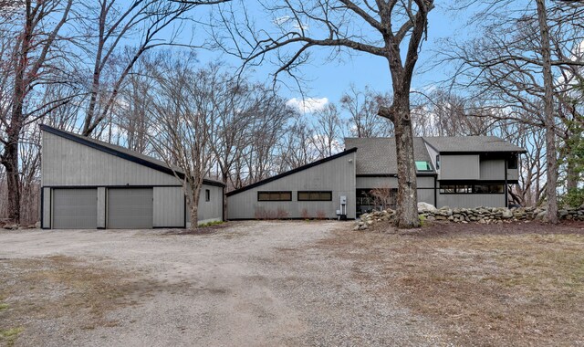 view of home's exterior featuring a shingled roof, an outdoor structure, and a garage