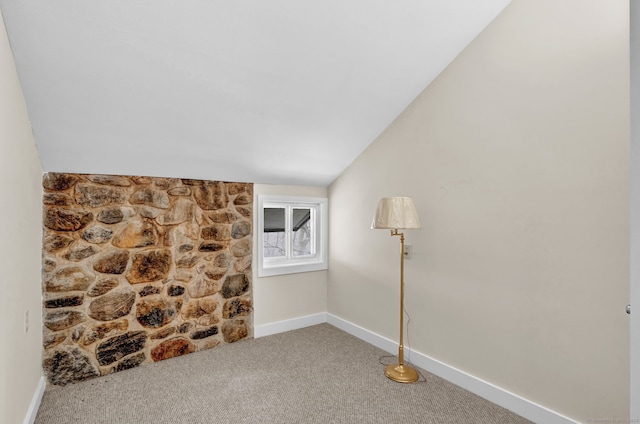 unfurnished room with lofted ceiling, baseboards, and carpet flooring