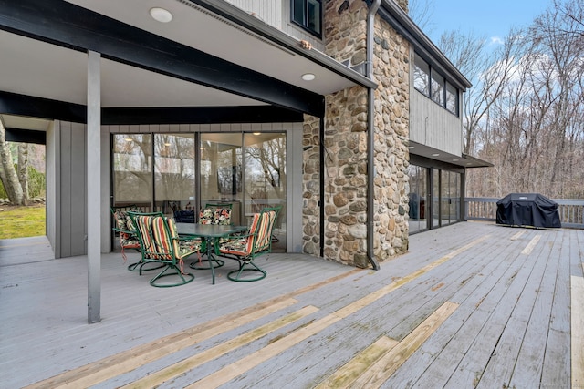 deck with a grill and outdoor dining space