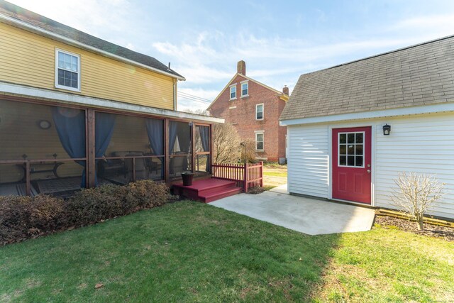 574 Fabyan Rd, Thompson, CT 06255 - rear view of property featuring a lawn, roof with shingles, a patio area, and a sunroom