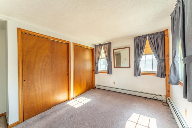 574 Fabyan Rd, Thompson, CT 06255 - unfurnished bedroom with baseboard heating, multiple windows, and multiple closets