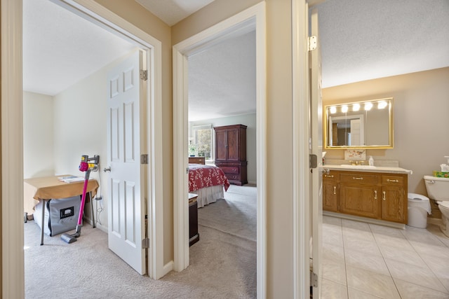 hallway with a sink and light carpet