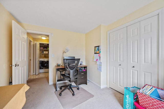 carpeted home office featuring baseboards and washer / clothes dryer
