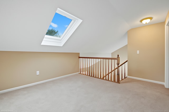 bonus room with carpet flooring, baseboards, and lofted ceiling with skylight