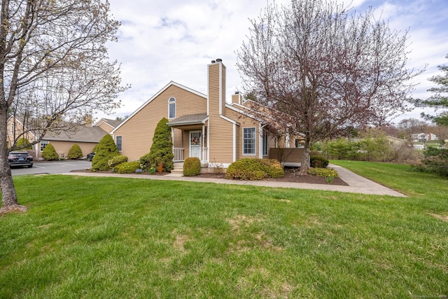 view of front of house featuring a chimney and a front lawn