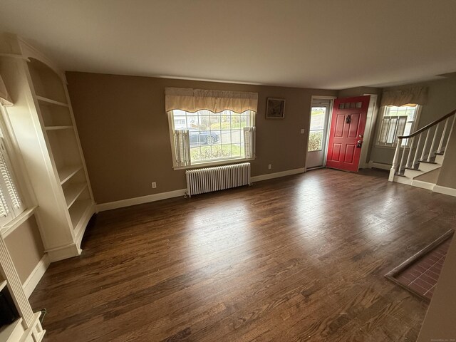 foyer featuring stairway, radiator, baseboards, and dark wood-type flooring