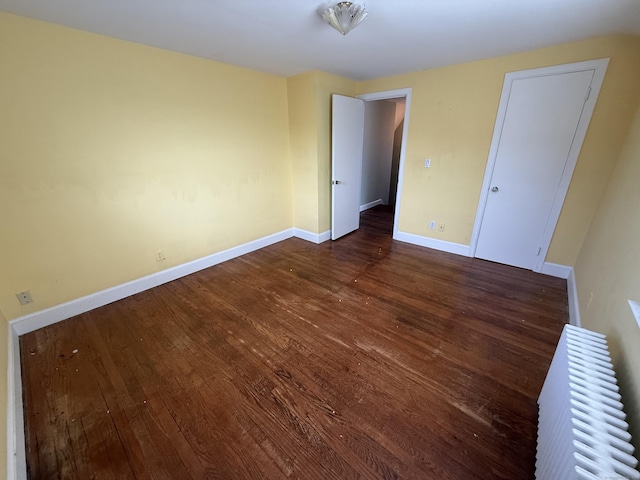 unfurnished bedroom with baseboards and wood finished floors