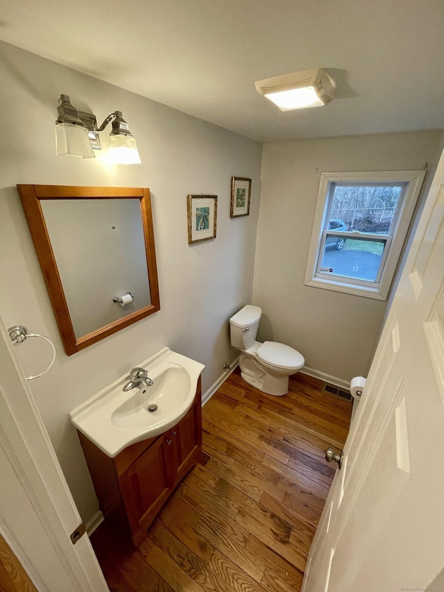 1895 Reservoir Ave, Bridgeport, CT 06606 - bathroom with visible vents, toilet, vanity, and wood finished floors