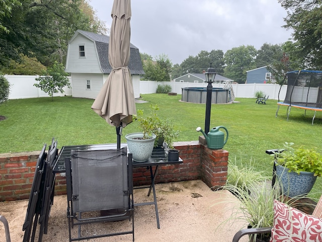 view of patio featuring a fenced in pool, a fenced backyard, and a trampoline