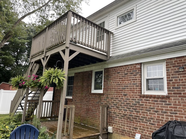 exterior space with brick siding and a deck