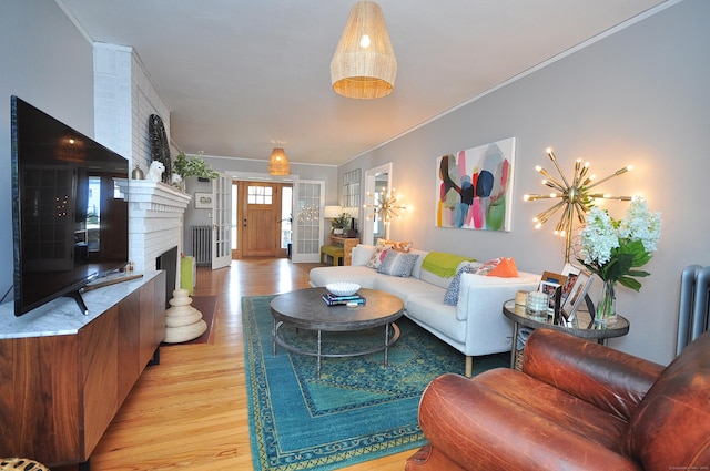 1186 Farmington Ave, West Hartford, CT 06107 - living area with light wood-style flooring, radiator heating unit, a brick fireplace, and ornamental molding