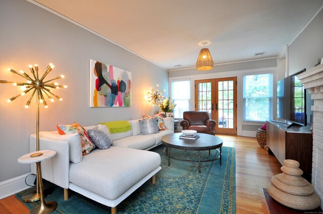 1186 Farmington Ave, West Hartford, CT 06107 - living area featuring french doors, crown molding, light wood-type flooring, a chandelier, and baseboards