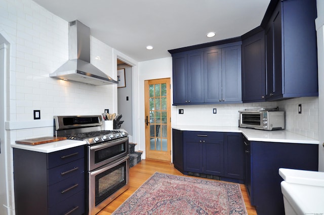 1186 Farmington Ave, West Hartford, CT 06107 - kitchen with double oven range, wall chimney exhaust hood, light wood finished floors, decorative backsplash, and light countertops