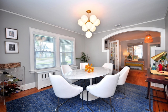 1186 Farmington Ave, West Hartford, CT 06107 - dining space featuring arched walkways, a chandelier, healthy amount of natural light, crown molding, and wood finished floors