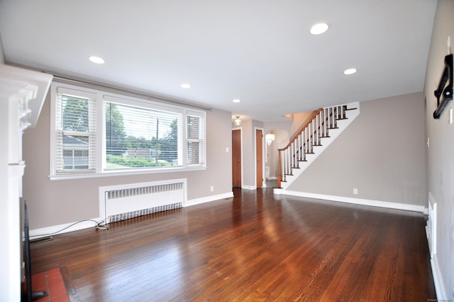 27 Brook St, New Britain, CT 06051 - unfurnished living room featuring radiator heating unit, stairs, wood finished floors, and recessed lighting