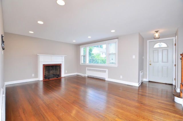 27 Brook St, New Britain, CT 06051 - unfurnished living room featuring radiator, a fireplace, wood finished floors, and recessed lighting