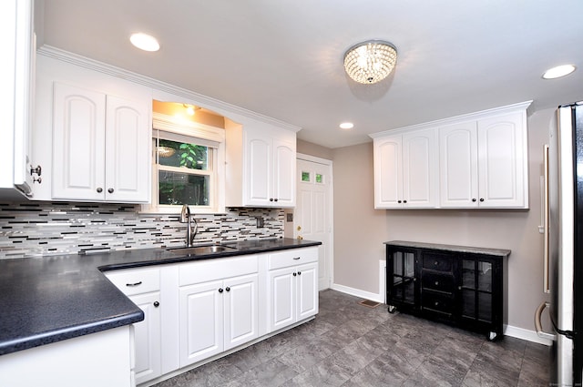 27 Brook St, New Britain, CT 06051 - kitchen with dark countertops, backsplash, white cabinets, freestanding refrigerator, and recessed lighting