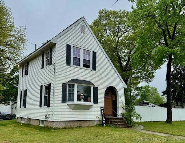 view of front of home featuring a front lawn and fence