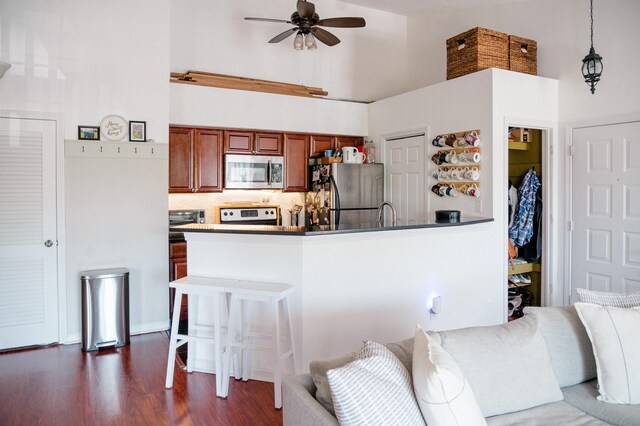 15 Forest Glen Cir Unit 19, Middletown, CT 06419 - kitchen with appliances with stainless steel finishes, a towering ceiling, a ceiling fan, brown cabinets, and dark wood-style flooring