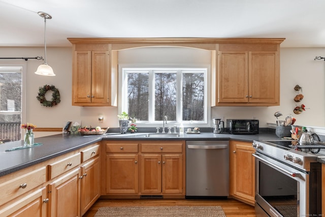 kitchen featuring a peninsula, dark countertops, visible vents, pendant lighting, and appliances with stainless steel finishes