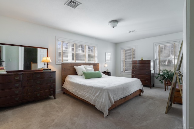 bedroom with visible vents, light carpet, and multiple windows