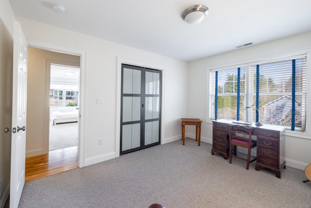 carpeted home office with baseboards and visible vents