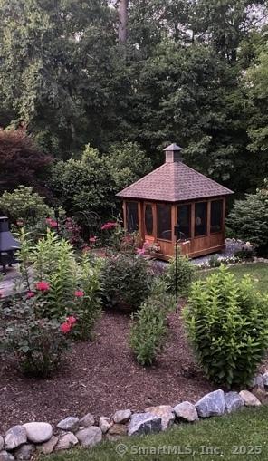 view of yard featuring a gazebo and a wooded view