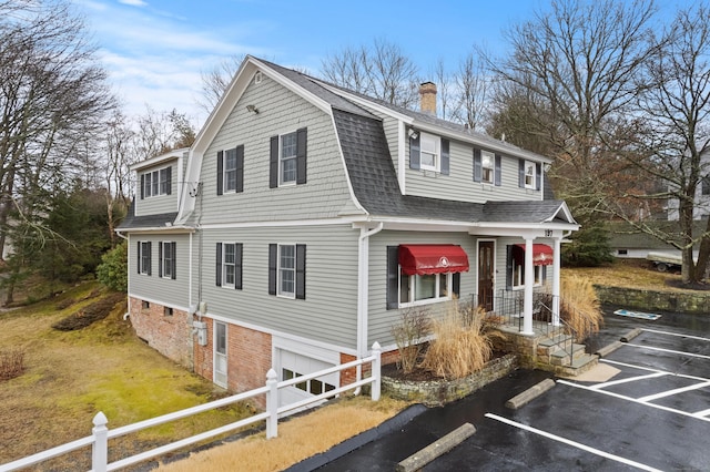197 Norwich New London Tpke, Montville, CT 06382 - view of front of property with uncovered parking, a chimney, fence, a gambrel roof, and roof with shingles