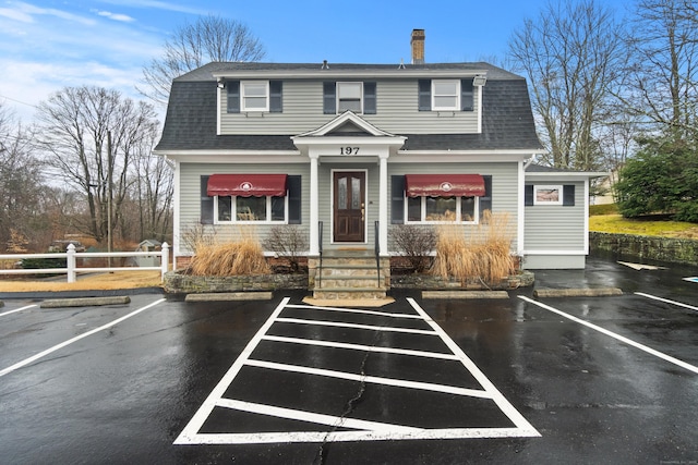 197 Norwich New London Tpke, Montville, CT 06382 - view of front facade with a gambrel roof, roof with shingles, a chimney, and fence