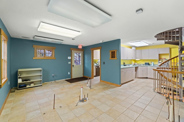 197 Norwich New London Tpke, Montville, CT 06382 - kitchen featuring white cabinets, light tile patterned floors, light countertops, and baseboards