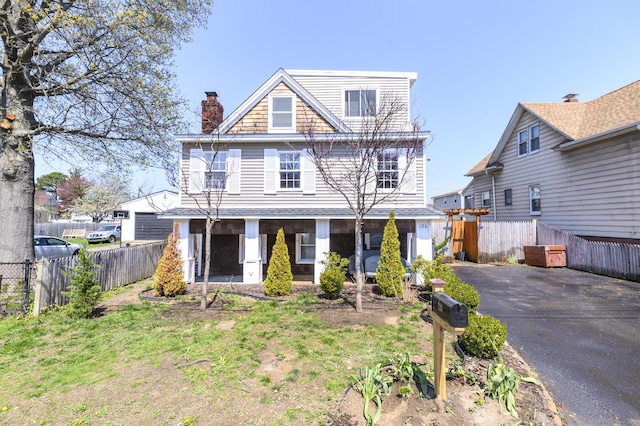view of front of property with fence, covered porch, and a chimney