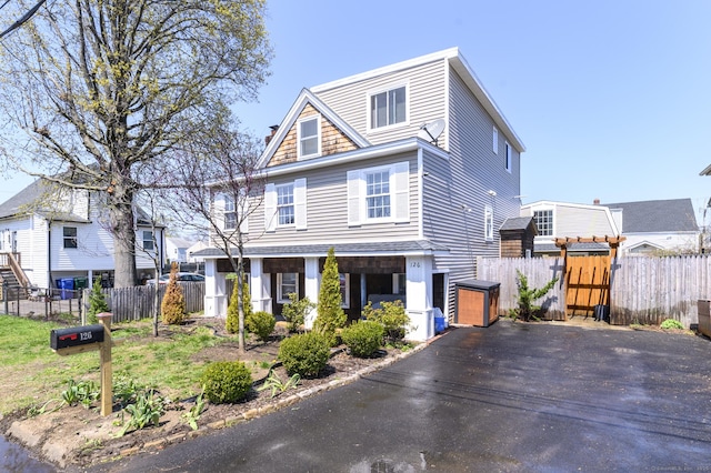 view of front of house featuring driveway, a gate, and fence