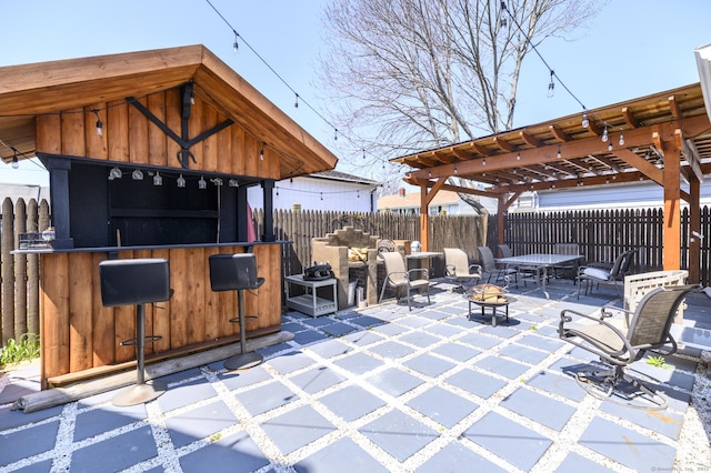 view of patio / terrace featuring an outdoor fire pit, fence, and outdoor dry bar