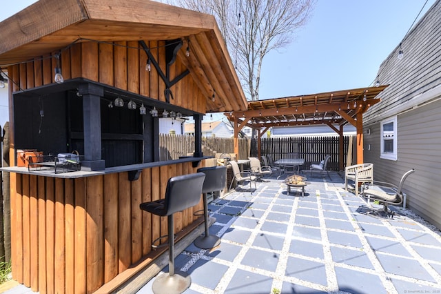 view of patio featuring a pergola, an outdoor fire pit, outdoor dry bar, a gazebo, and fence