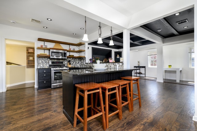 kitchen with appliances with stainless steel finishes, visible vents, tasteful backsplash, and baseboards